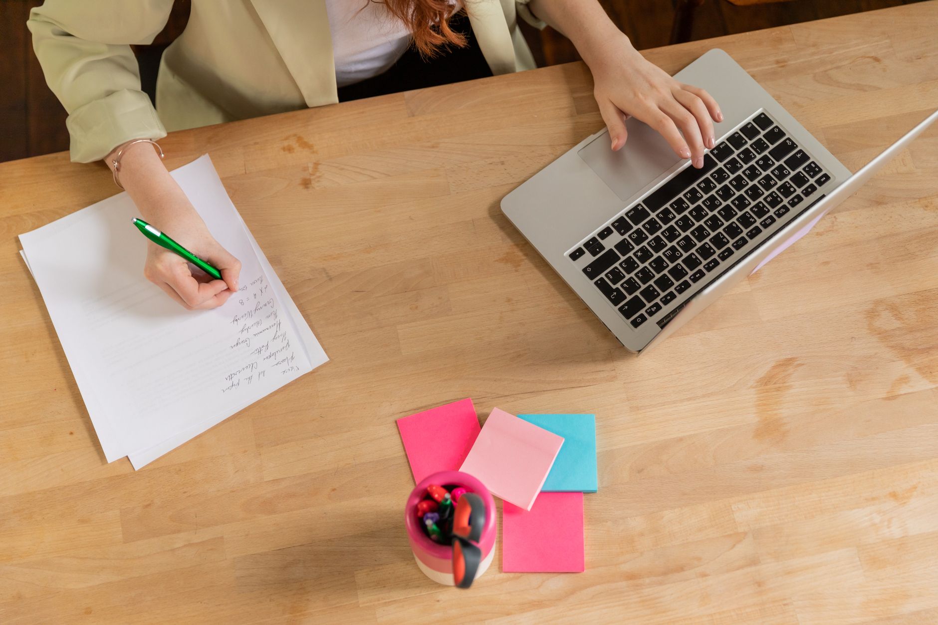 Solo worker at a sparse desk with one laptop and a few paper notes