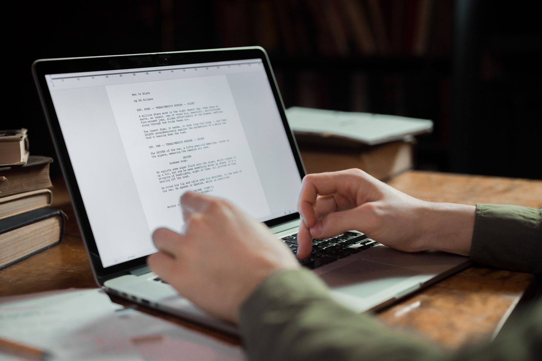 a person reviewing and editing an article on a laptop at a desk